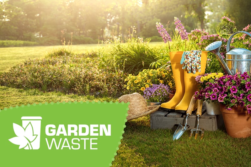 A pair of yellow wellies and garden tools on a sunny day. Sign up to the garden waste service