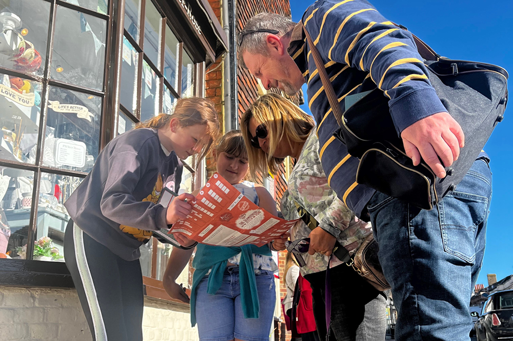 A family looking at a Mystery Trails map