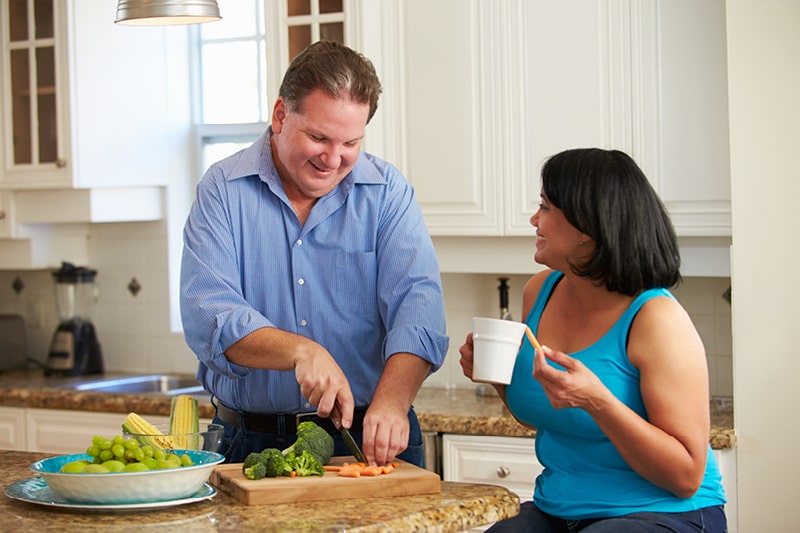 Man cutting up vegetables in kitchen