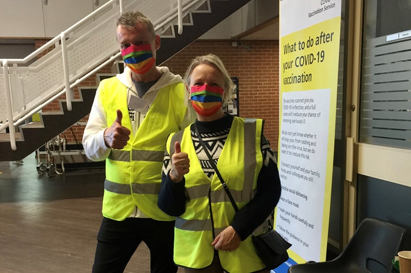 Two volunteers with their thumbs up