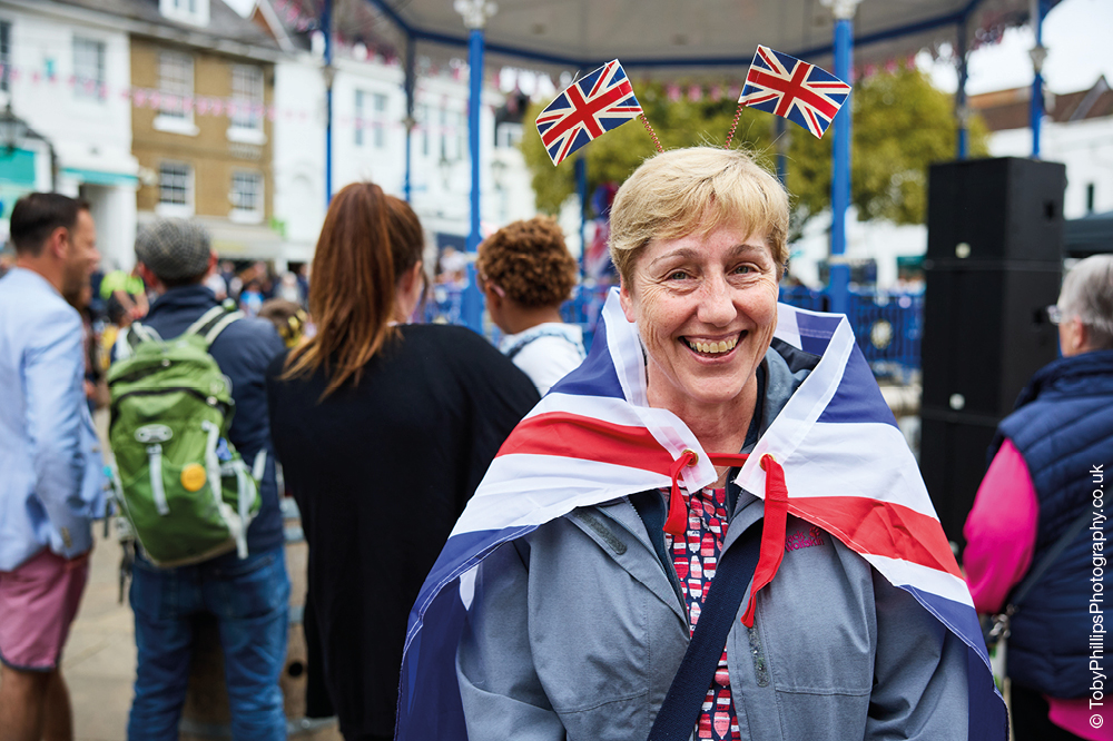 A woman with a union flag around her shoulders and a union flag hairband