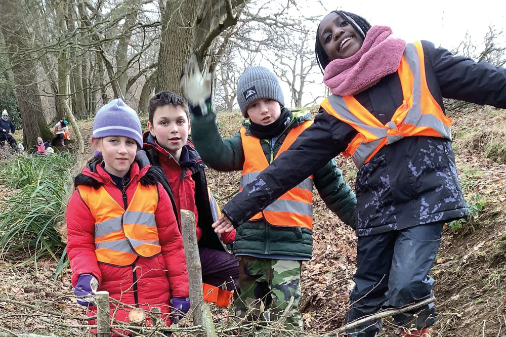 Children smiling in high visibility jackets